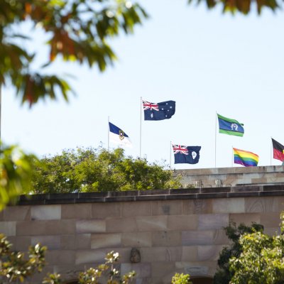 The rainbow flag flies alongside the Australian and Aboriginal Flags on top of UQ's Forgan Smith building.
